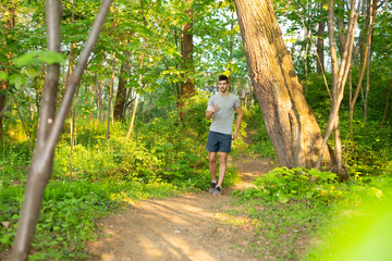 Naklejka na ściany i meble Young man jogging outdoors in nature