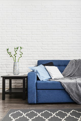 Blue couch with pillows and grey plaid