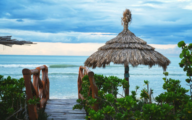 wooden bridge and a parasol at the beach on isla holbox