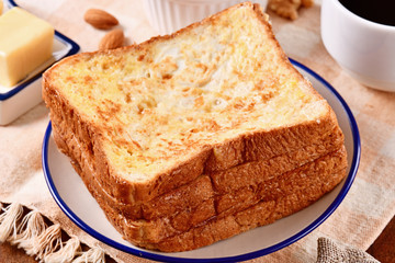 Golden brown french toasts on white plate.  