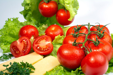 cherry tomatoes on lettuce leaves on white background