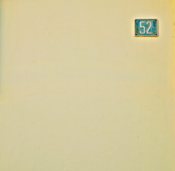 Number 52, fifty-two, blue offset plate on square pale yellow background.