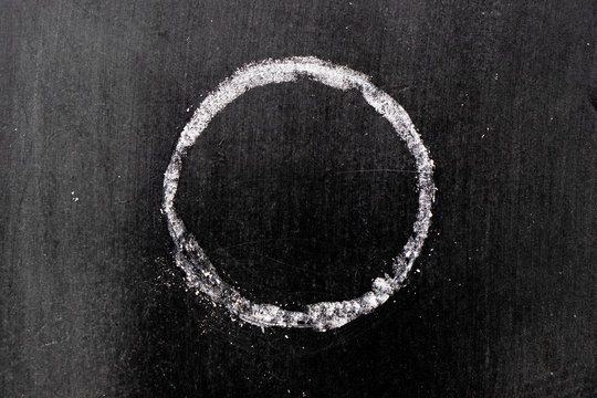 White chalk hand drawing in circle or round shape on black board background