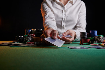 Croupier hands out cards on the background of casino chips