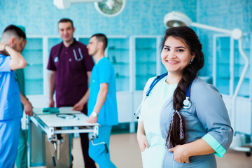 Fototapeta premium Portrait of a successful professional doctor. The staff of the medical faculty. multinational people - doctor, nurse and surgeon. A group of graduates of a medical university in a surgical room.