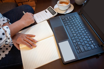Women working in coffee shops have coffee cup, laptop, calculator and documents. Startup and Freelance concept