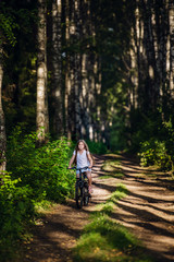 Obraz premium Little girl having fun on bike in the forest in autumn season