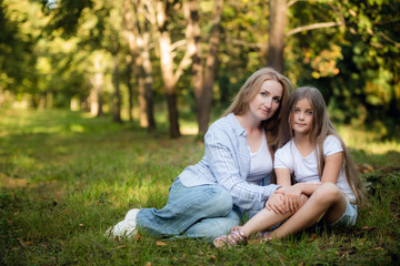 Mother and baby girl sitting and relaxing in park.