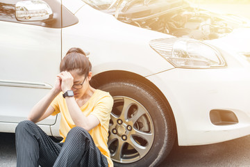 Young stressed woman having trouble with her car breakdown on the road and she waiting someone can...
