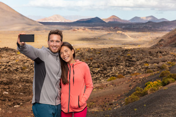 Selfie couple tourists taking self-photo picture with mobile phone on travel vacation. People...