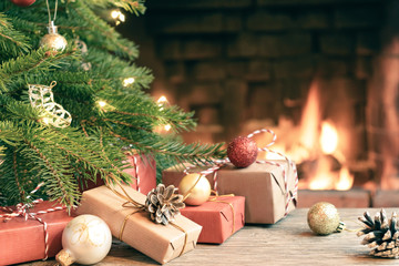 Gifts under the Christmas tree in the room with a fireplace on Christmas eve - Powered by Adobe