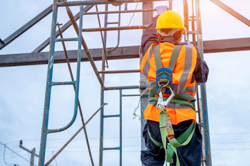 Construction worker wearing safety harness belt during working at high place.