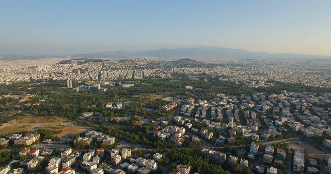 Aerial shot of urban sprawl in Athens Greece. Huge neighborhood of similar houses. Realtime wide angle shot with a rising camera during sunrise in the daytime exterior.