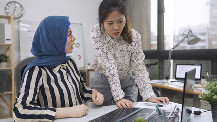 Multiracial asian chinese and arabic colleagues disputing having disagreement at work blaming each...