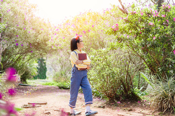 cute child girl dreaming on the walk in summer with holding book
