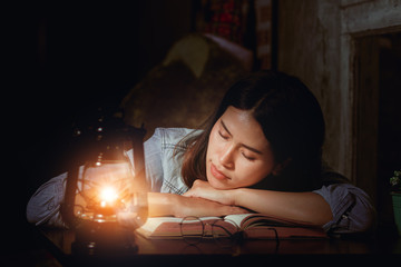 Asia woman tired from reading book sleeping with happy.