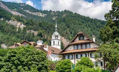 Switzerland, old church and houses near green Alps