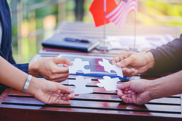 Obraz premium Business people putting connect jigsaw puzzle. Team work and strategic solution concept with America and China flag as background.