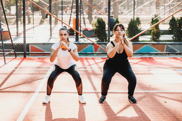 Body positive woman doing exercises with her girlfriend in a sport park in the morning.
