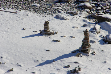 Winter cairns on the sea, covered with snow and ice.