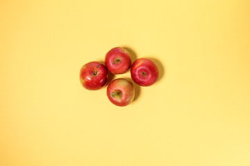 Small mini red apple on yellow background