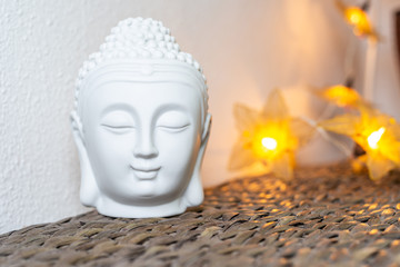Miniature white buddha head & face. Illuminated background. Home decoration ornaments.