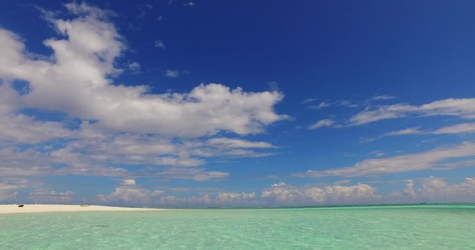 Impressive big clouds on a blue purple sky over bright turquoise lagoon washing white beach in Indonesia , copy space