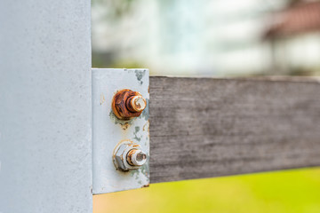Rusty nuts and bolts on wood fence