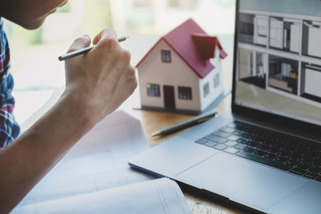 Engineer are planning to drawing house structure on Blueprint and sketch house on computer for his customers.