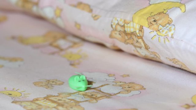 Baby bed with a case in the form of a mouse for the tooth fairy. The mouse-case lies on the girl's bed. The movement of the frame from left to right. Close up