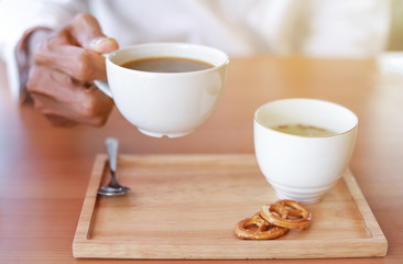 man hand hold hot coffee for healthy drinking 