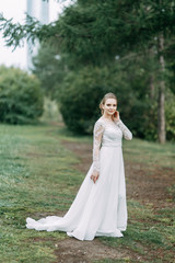 Elegant ceremony in European style. Beautiful bride in white flying dress in the forest.