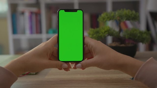 Close up hands young woman use smartphone phone with vertical green screen sitting at desk technology internet sitting business device female home mobile app communication display holding slow motion