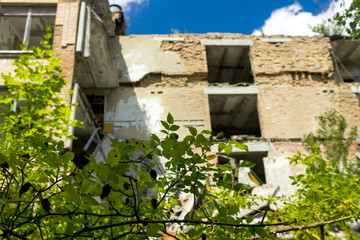 Fototapeta premium The ruins of residential buildings, the dark trash of collapsed houses as a result of the economic crisis and earthquake. The interior of the old buildings is destroyed.