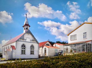 Street view of St. Mary's Church and quaint wooden residential houses in downtown Stanley, the...