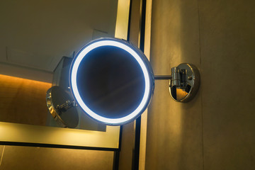 close up glowing round mirror in hotel bathroom for women make up