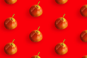 Creative pattern made of pears on red background.