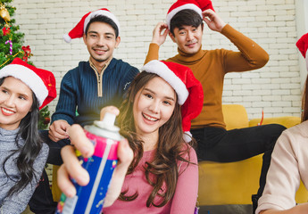 Group of young smile people in winter season playing and feel funny from color string spray for celebrate in Christmas party