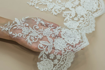 Texture lace fabric. lace on white background studio. thin fabric made of yarn or thread. a background image of ivory-colored lace cloth. White lace on beige background.