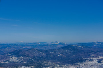 Fototapeta premium Winter landscape in Sheregesh. Frozen snow on trees. Frozen trees on a background of blue cloudy sky. A lot of snow fell in the winter cold in the mountains. Sunrise in the mountains