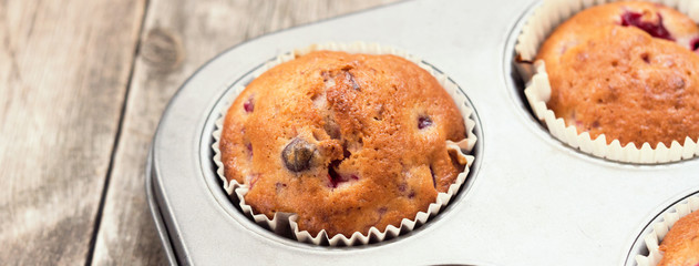 Freshly baked cherry muffins closeup in baking tray