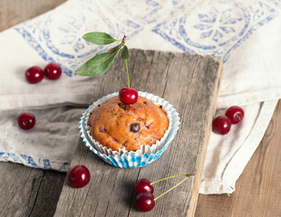 Freshly baked cherry muffins closeup on a rustic table