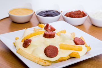 Colombian salchipapa with cheese and sauces