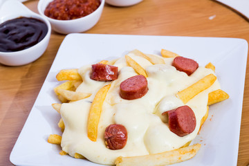 Colombian salchipapa with cheese and sauces