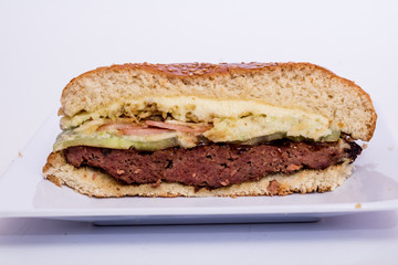 halved cheeseburger on white background