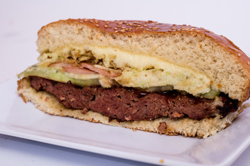 halved cheeseburger on white background