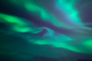Stunning aurora borealis. Shape of fast mooving lights of crown aurora. Looking directly up in the sky. Northern ligths, green purple and blue colors. Tromso, Norway. - obrazy, fototapety, plakaty