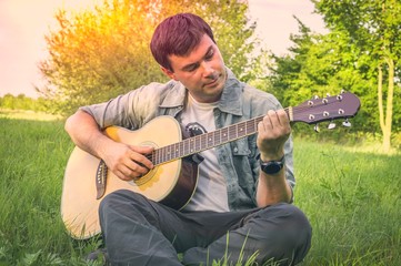 Handsome man playing on acoustic guitar