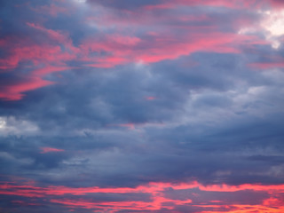 Thunderclouds on a sky background illuminated by the sun's rays of the setting sun