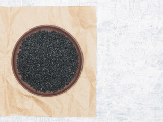 Obraz na płótnie Canvas Spices help maintain good health and improve appetite, top view on craft paper and concrete background. Black cumin, caraway in clay plate. Modern apothecary, naturopathy and ayurveda concept.